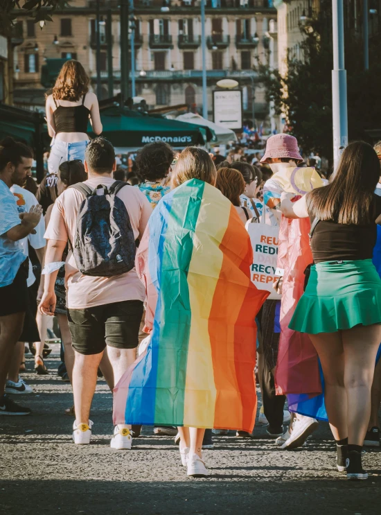 a group of people with rainbow colored flags