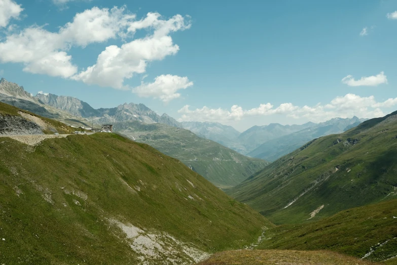 mountains rise over a valley on a partly cloudy day