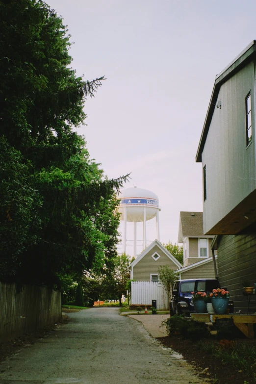 the white water tower is behind the houses