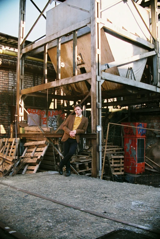 the person is leaning against the building and posing for the camera