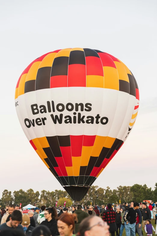 a large  air balloon with people on the ground nearby