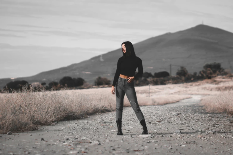 a woman standing in the middle of an empty road