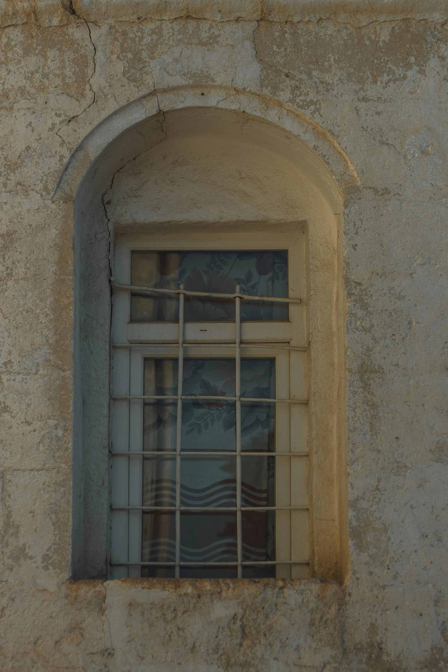 a wall with an open window and bars on it