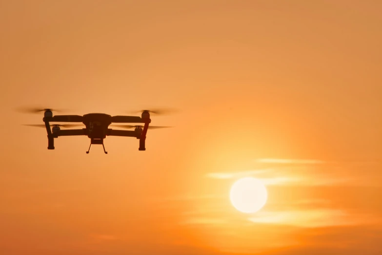 an air plane flying in front of the setting sun