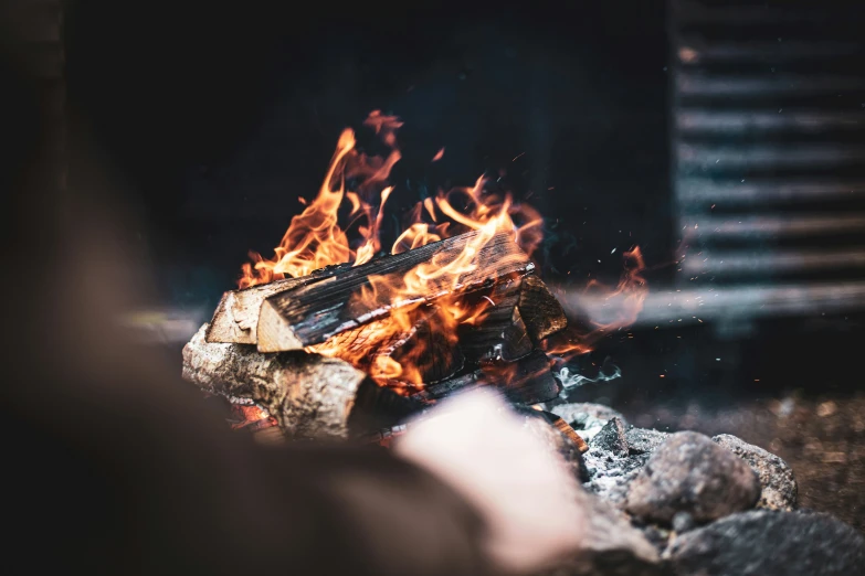 an open flame with rocks and grass in the foreground