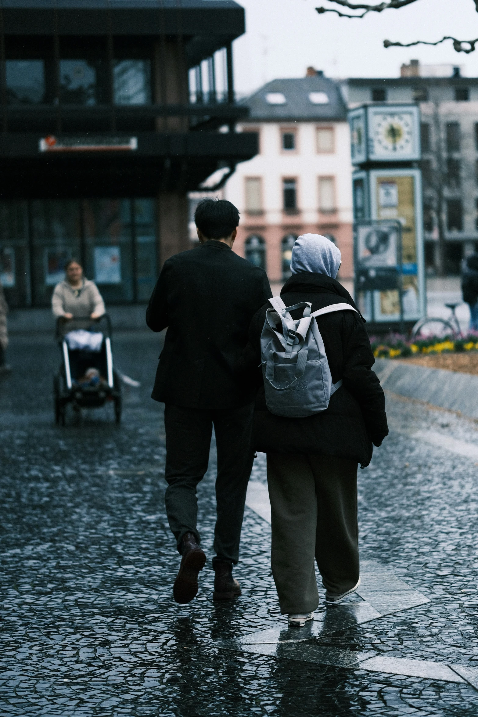 two people walking in the rain on a city street