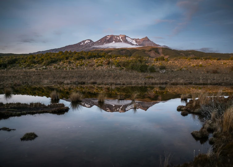 a snow - covered mountain with a mirror like landscape