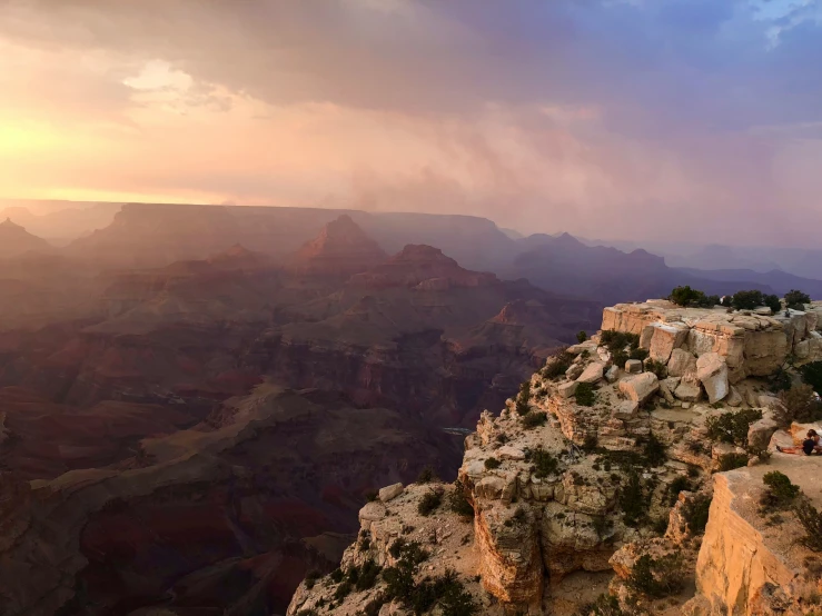 sunset at the grand canyon with clouds moving over the edge