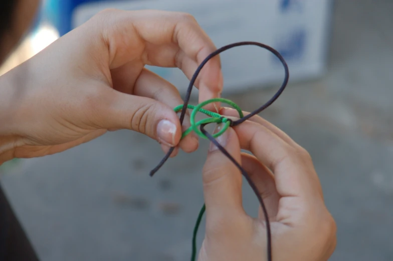 a pair of hands working with wires and string