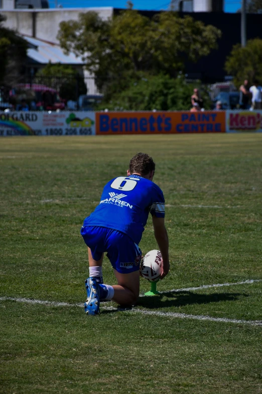 a soccer player on the field with his knee bent over