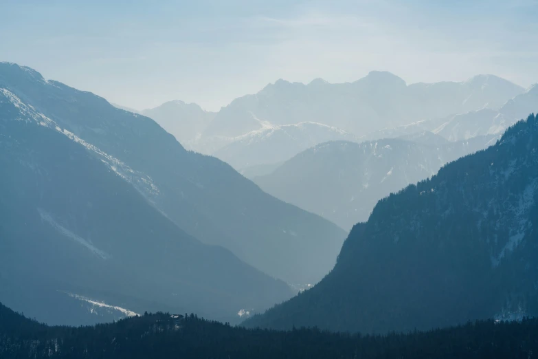 a group of mountain peaks in a foggy valley