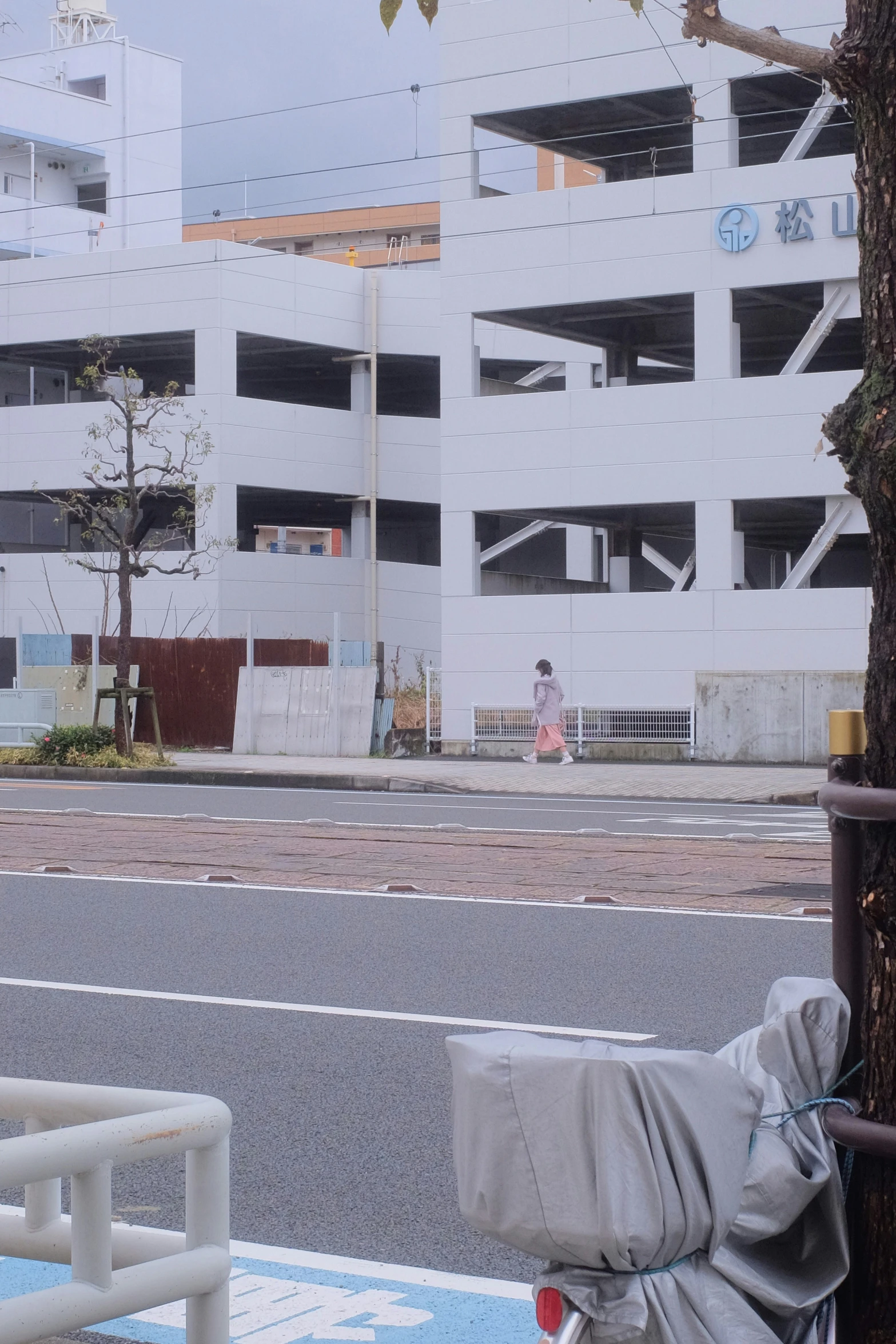 a white building next to a street with the sidewalk covered by blankets