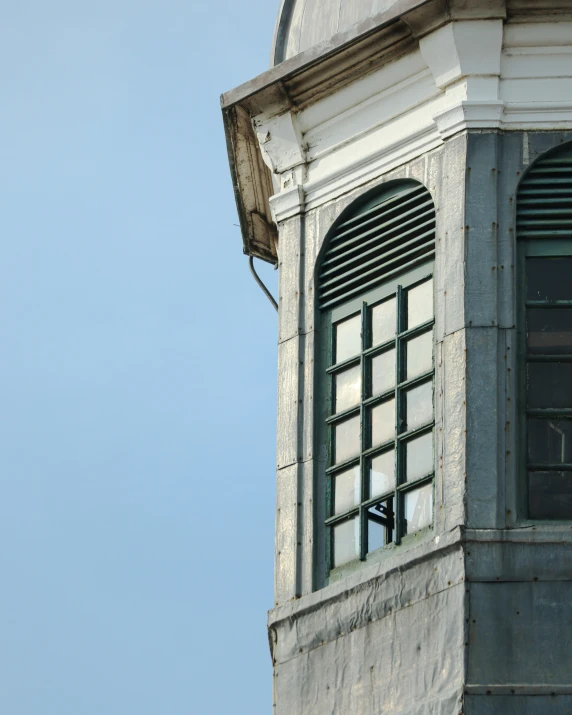 a clock on the outside of a building next to a weather vane