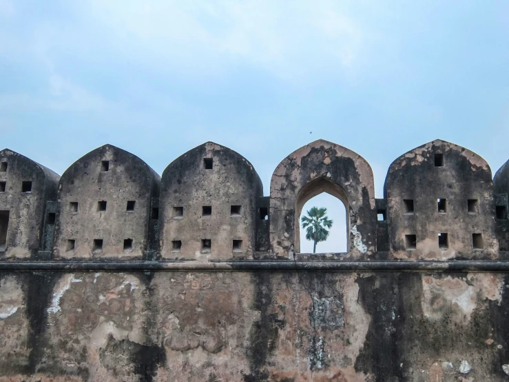 a wall with an arch and small window