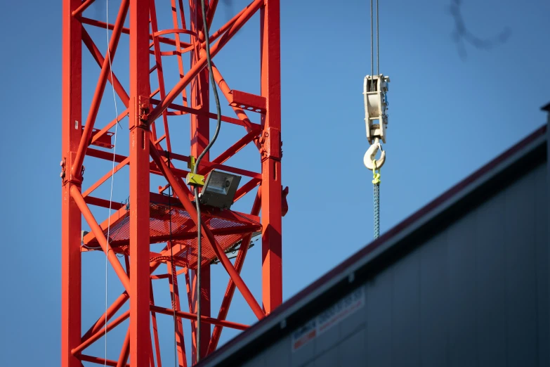 a crane hanging upside down next to a building