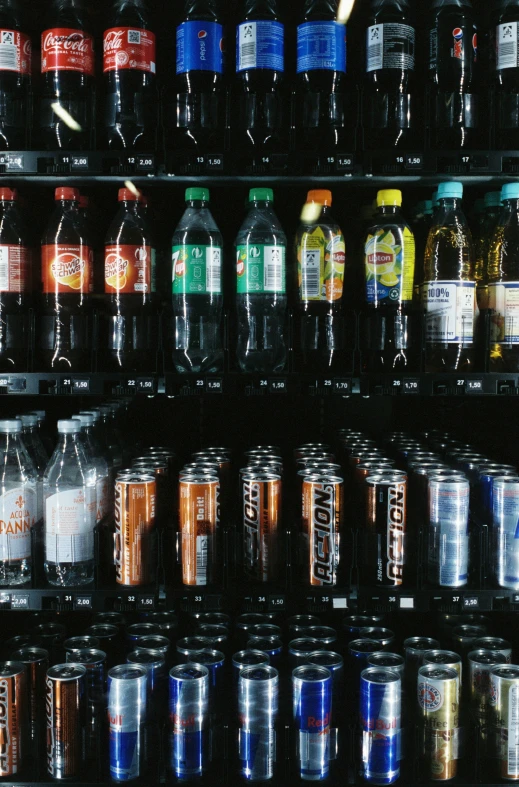 many kinds of sodas are displayed in a cooler