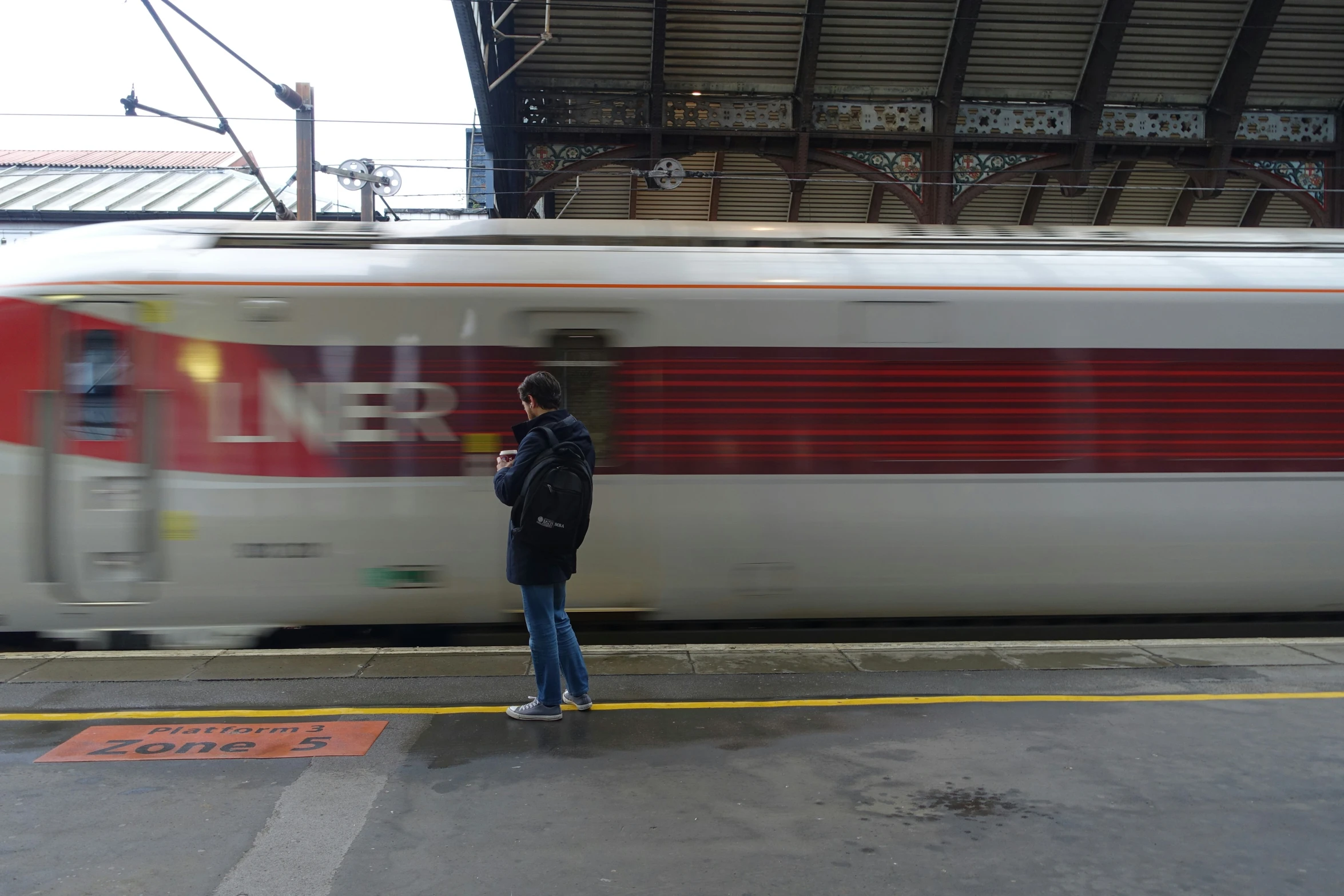 a man stands in front of a train at a train station