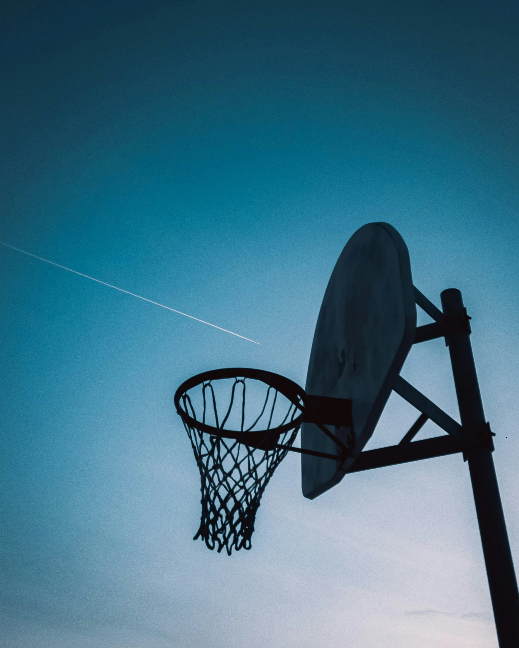 the backboard of a basketball hoop in twilight