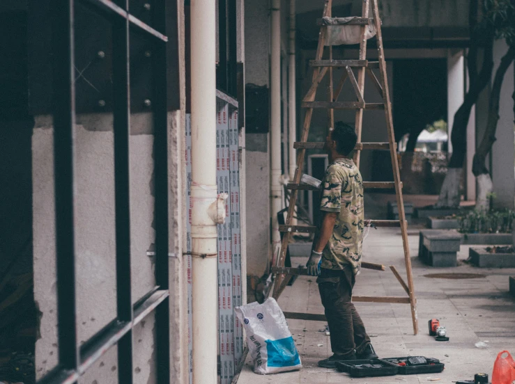 a man in a uniform standing by the side of a building