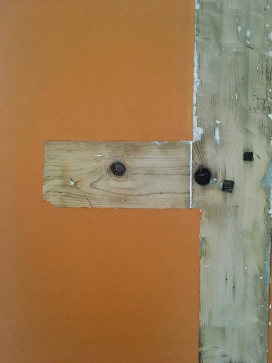 cross in center of wooden planks with paint peeling off