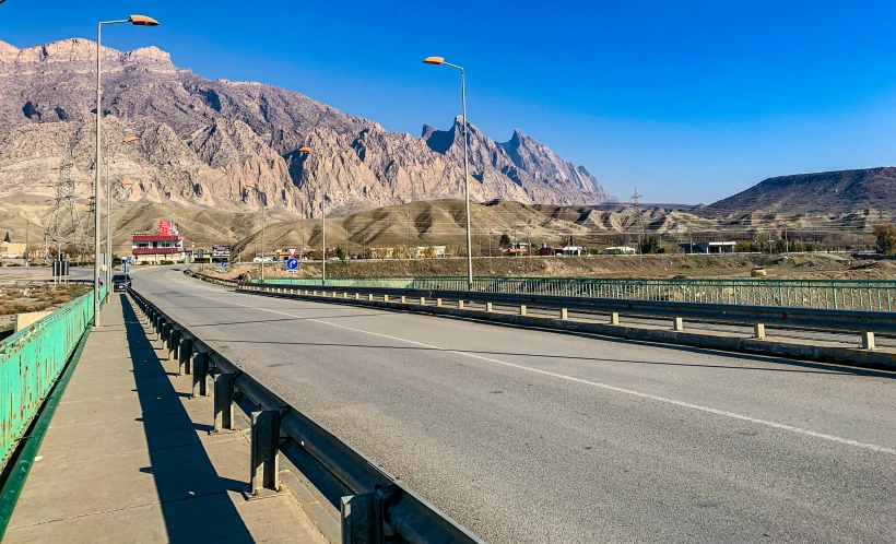 a very big wide and open highway with mountains behind it