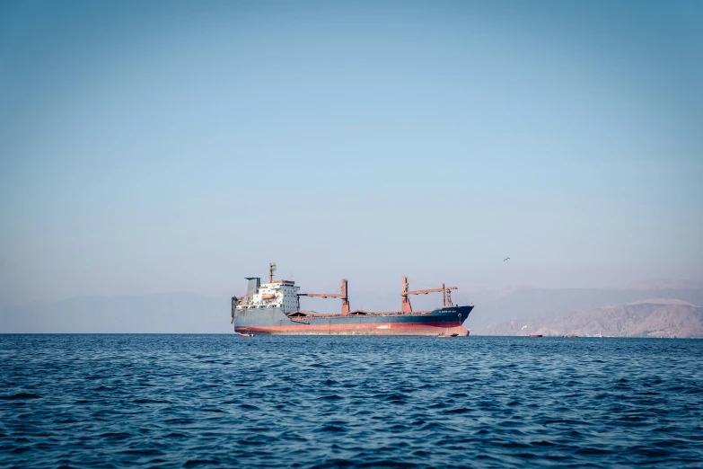 a large boat floats away from a larger boat