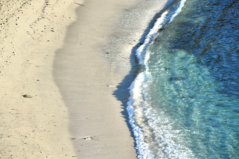 the water along a beach is crystal blue