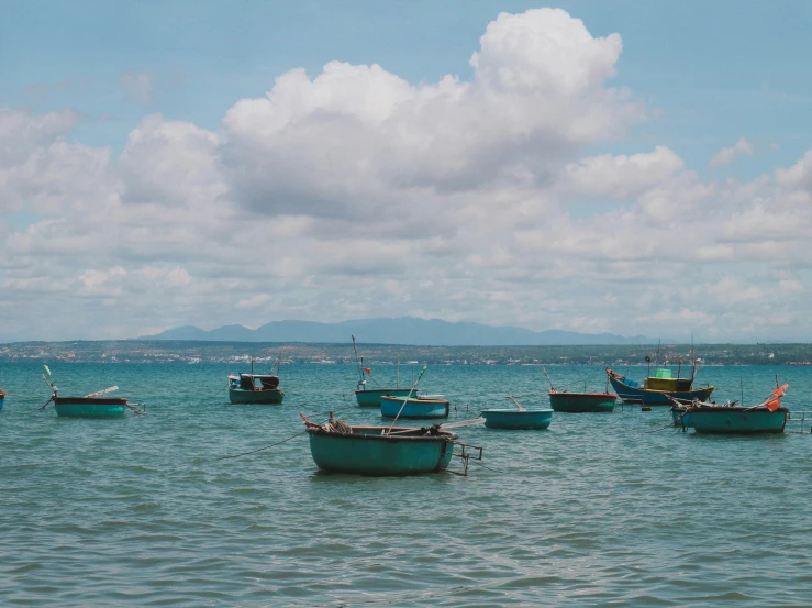 a number of small boats in the water near a beach
