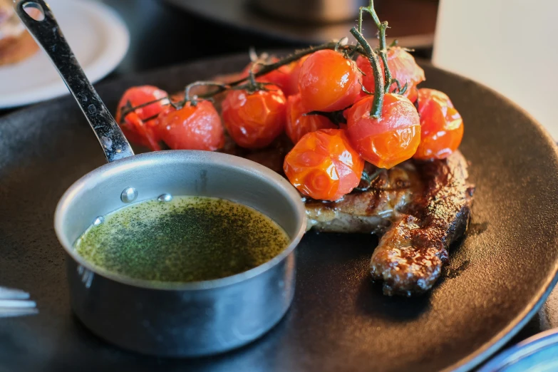 a plate topped with meat and tomatoes on top of it