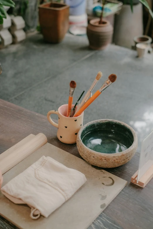 the pottery bowl holds two pens and 5 brushes