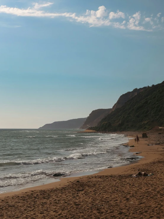 a man is riding a surfboard towards the water on a beach