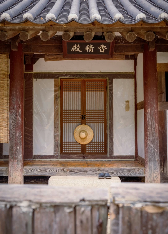 a doorway with wood fencing and traditional asian decoration