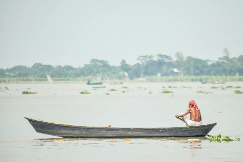 there is a man in a hat on the boat in the water