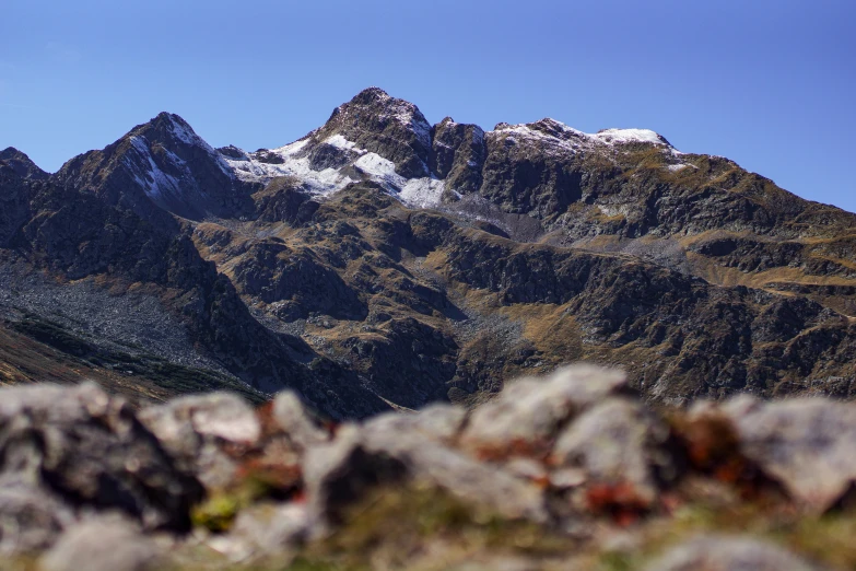 a mountain covered in snow and green grass