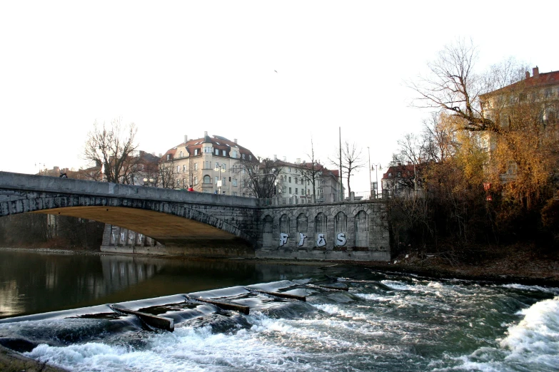 a city is depicted with old stone buildings along the river