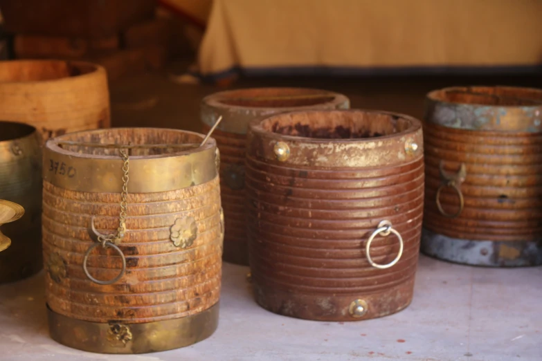 some big brown buckets are lined up and sitting