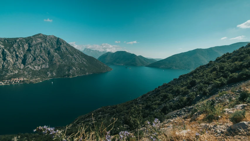 a view of mountains, lakes and a forest