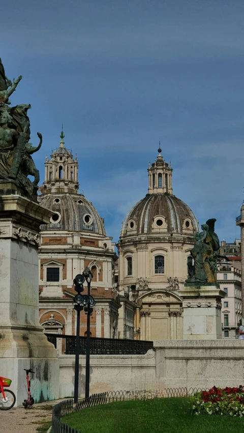 statues, a building, and a clock on a street corner