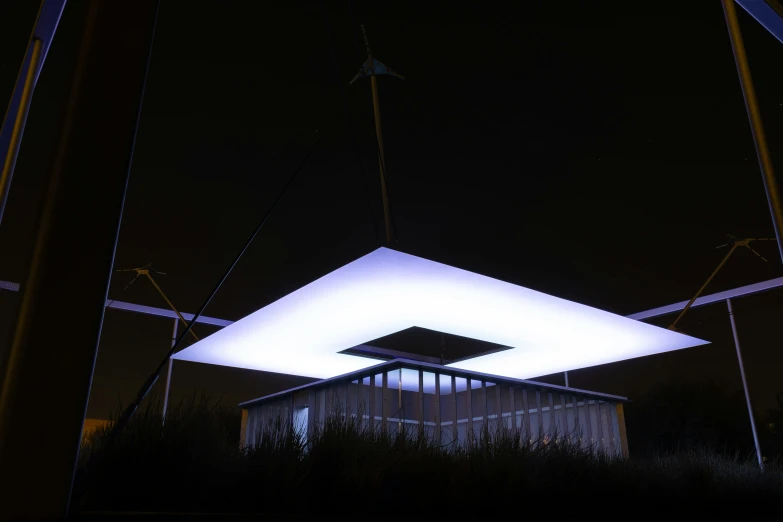 a building at night with bright lights and a lit triangle