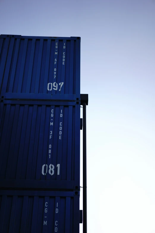 blue shipping containers stacked up on top of each other