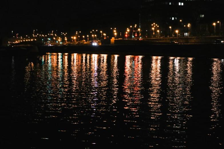 reflection on water at night with large city lights