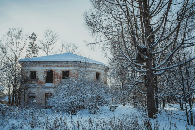 old building in the middle of a snow covered forest