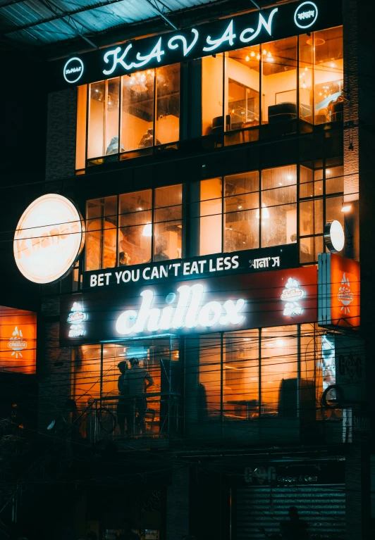 a neon sign on the side of a building with a bar