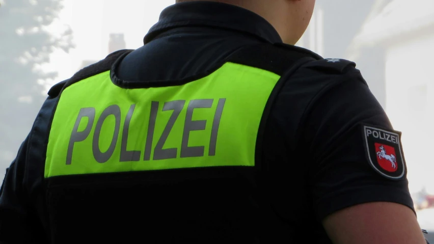 a man wearing a police uniform standing by a truck