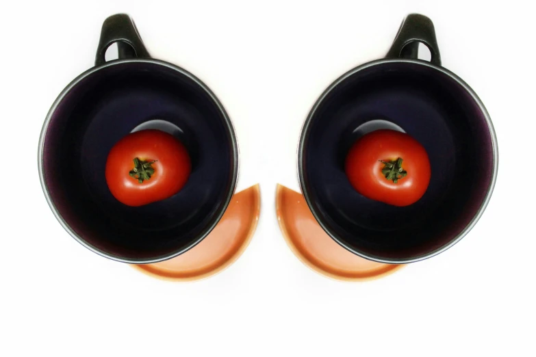 two speakers with a tomato on one side and a small piece of metal on the other side