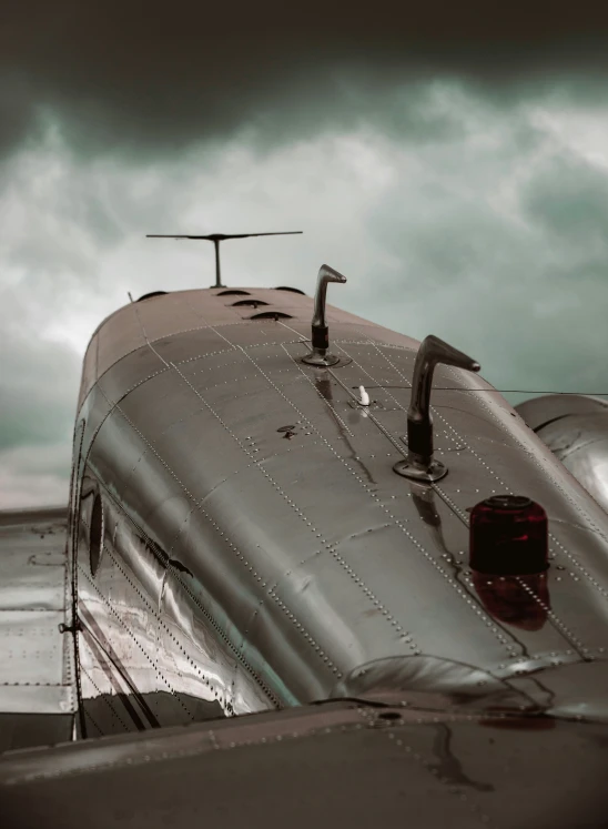 the tail end of an airplane with clouds and dark skies