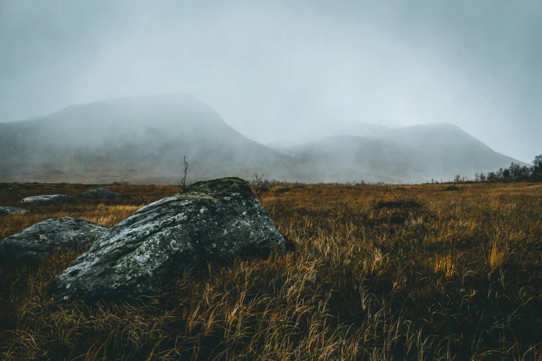 large rocks are on the side of a grassy field