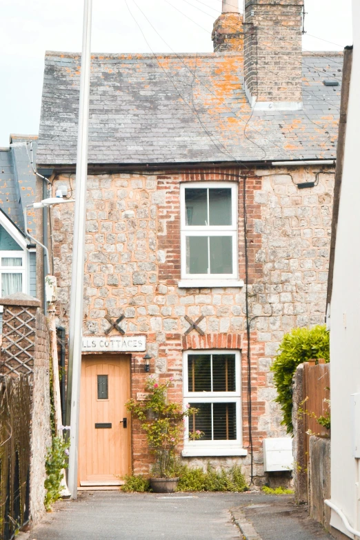 a cobblestone home with a red door