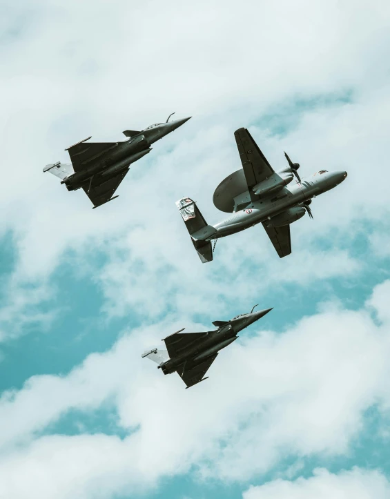 a group of planes flying through the blue sky