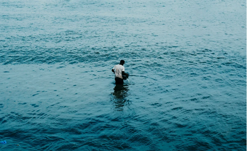 the man in the water is sitting on his knees